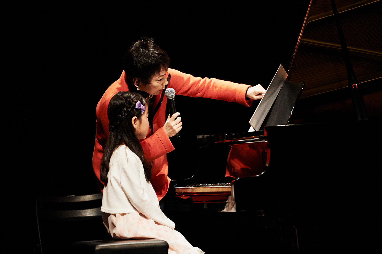 山田香音さんの演奏後に、「mf、mpって分かる？」と楽譜を指さしながらアドバイスする熊本さん