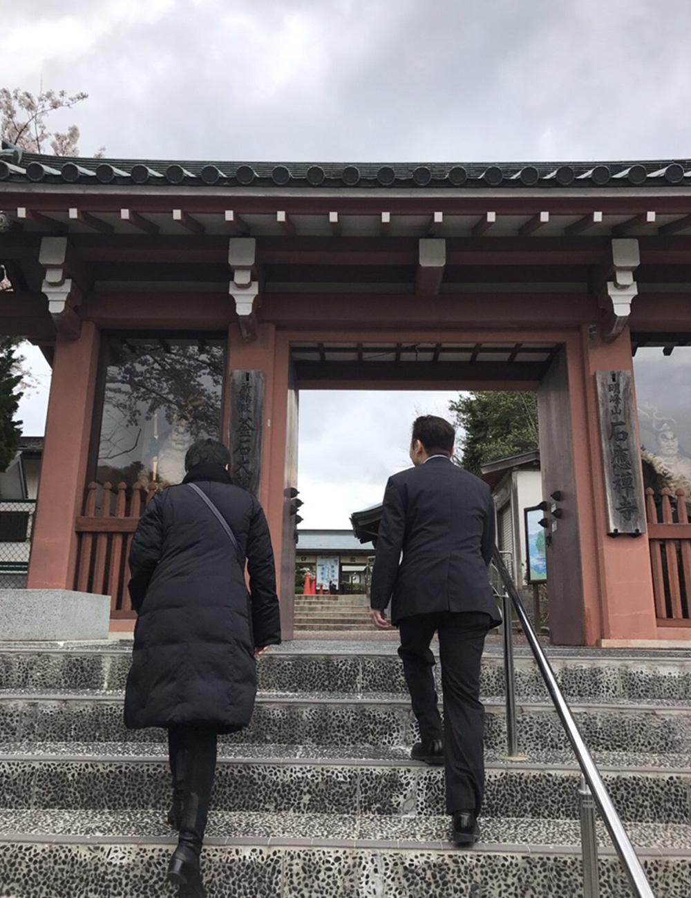 観音堂へ続く階段を上る熊本マリさんと、釜石PIT ホールマネジャーの井筒さん