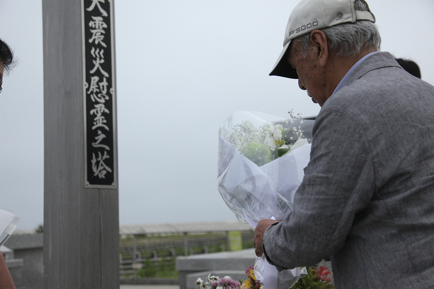 東日本大震災慰霊塔にて。花を献じた後、帽子を取って30秒の黙祷を全員で。